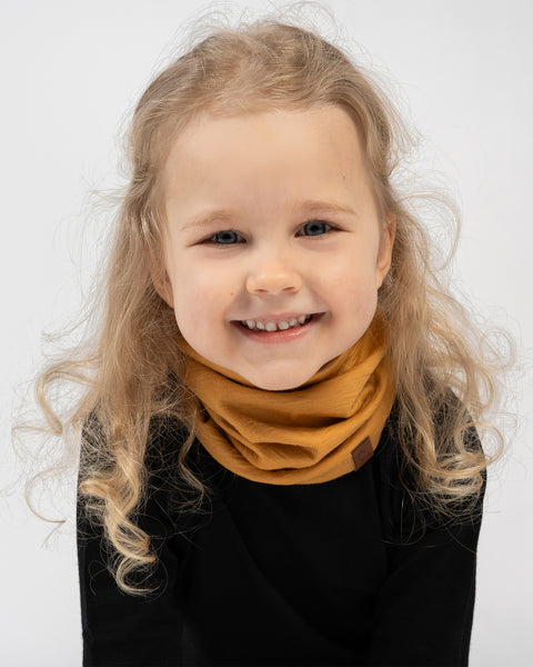 Happy toddler in merino wool neck warmer scarf and black thermal shirt