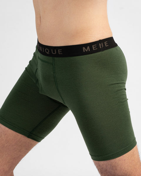 A close-up side profile shot highlighting a man wearing dark green long boxer briefs. The fitted underwear features a contrasting black elastic waistband with the "MENIQUE" logo.