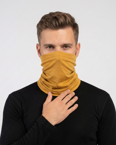Man wearing yellow merino wool long neck gaiter covering face, warm breathable wool accessory for hiking and outdoor sports.