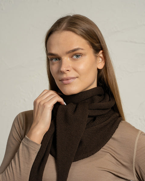 Nærbillede af brun merinouldsstrikket bandana tørklæde viklet om halsen.