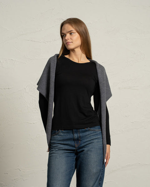 Mørkegrå strikket merinouldsbandana båret som en hættehalstørklæde på en kvinde.