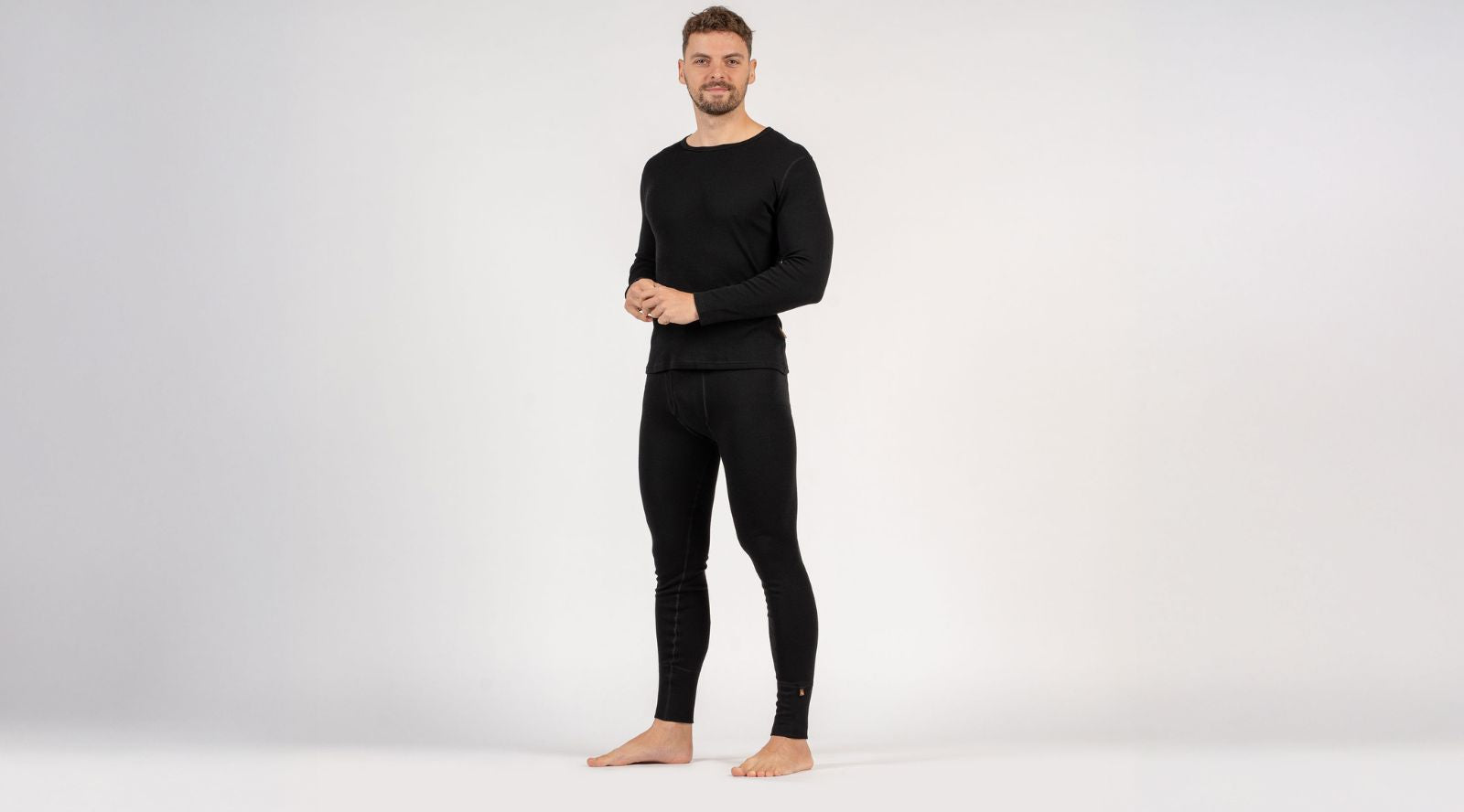 Man wearing black thermal underwear on a white background