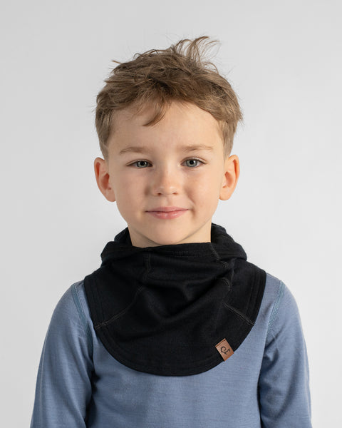 Young boy with uncovered wavy hair wearing a black fleece or knit neck gaiter collar over a light blue top.