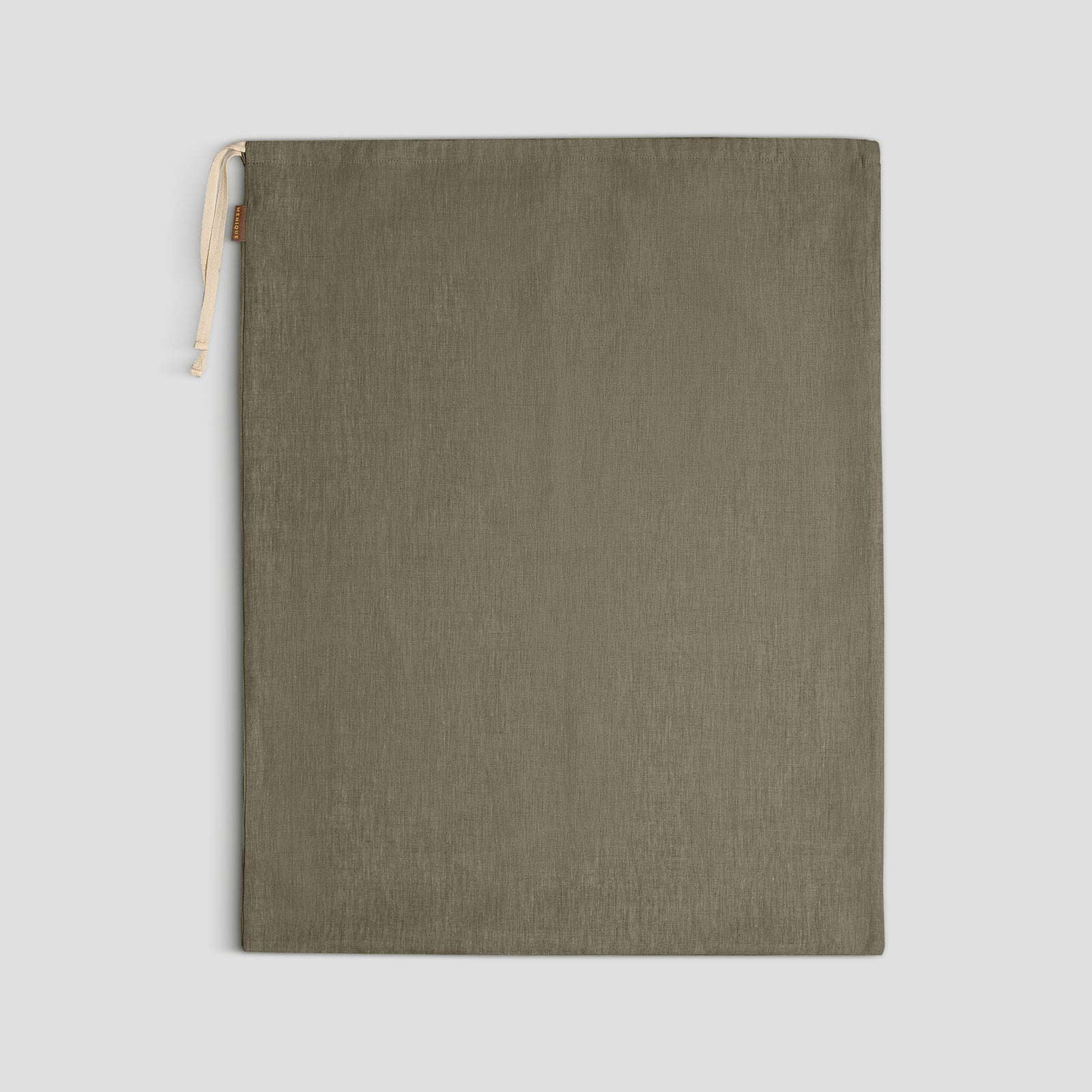 An open suitcase is neatly packed with four cloth drawstring bags of different sizes and colors (two olive green and two light beige) on a wooden surface.