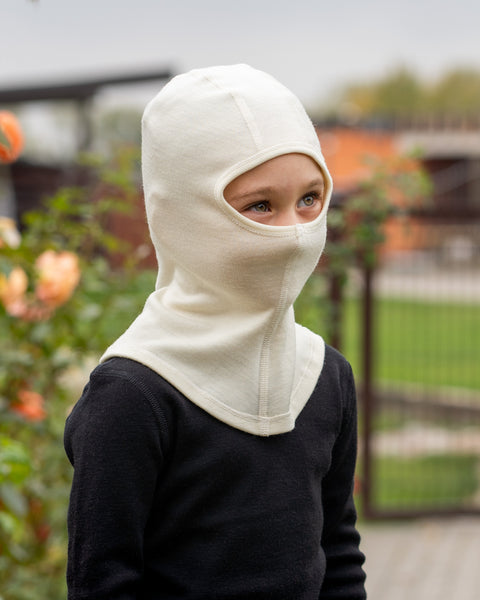 en pige iført merino 250gsm balaclava ansigtsmaske i farven natur