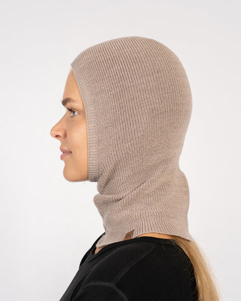 Sideprofil af kvinde iført en cremet beige strikket balaclava i merinould.