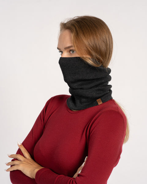 Woman in red shirt with dark gray knitted Merino wool gaiter pulled up over the face, side view.