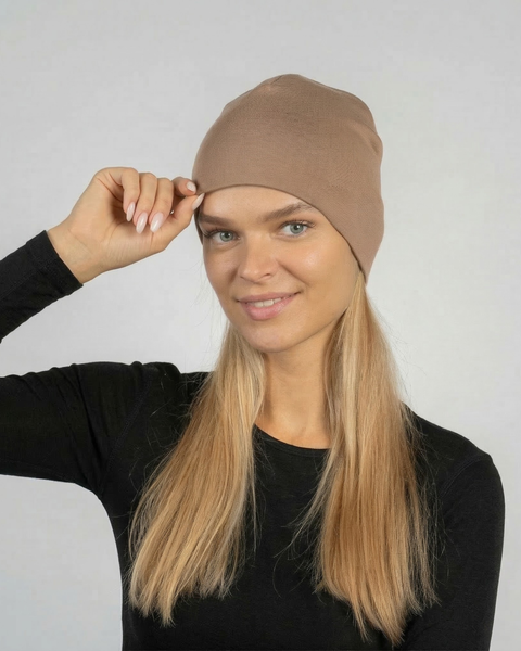 Woman wearing beige merino wool beanie hat, lightweight breathable merino wool hat for women designed for everyday wear, outdoor activities, and natural temperature regulation.