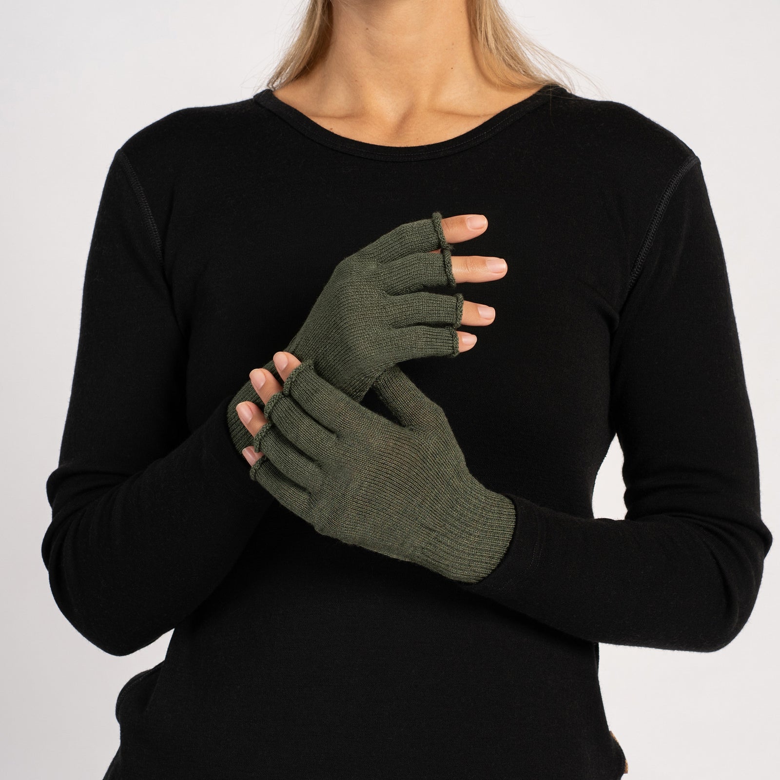 Close-up of a woman’s hands wearing creamy-beige fingerless merino gloves, palms facing inward and fingers visible.