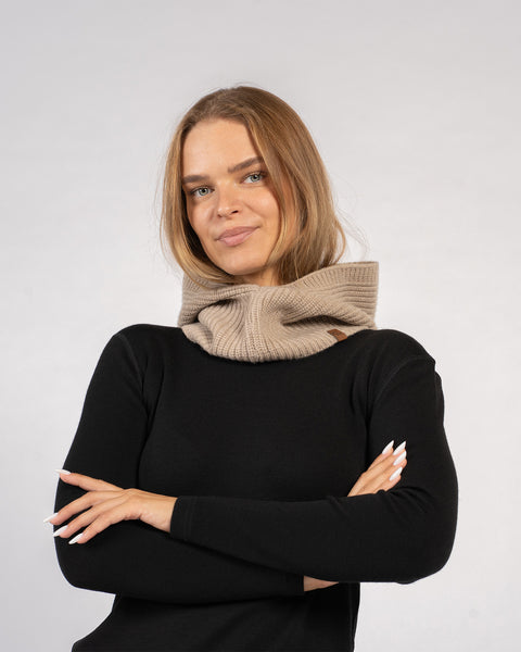 Kvinde iført strikket balaclava med rib i kashmirblanding og hætte i cremet beige – hyggeligt vintertilbehør