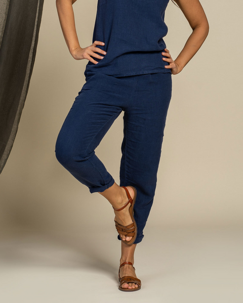 Person iført et stormblåt høroutfit med brune sandaler på en neutral baggrund