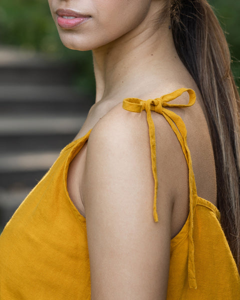 Kvinde viser skulderstropperne på sin kjole